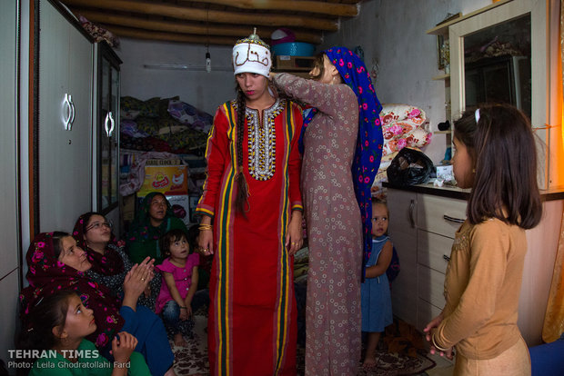 They prepare the bride for the ceremony by wrapping a white cloth around her head wishing her a happy life.