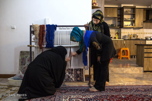 Hosseini is checking up on one of the carpets her trainee is weaving ordered by Portugal.