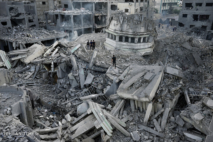Palestinians inspect the rubble of the Yassin Mosque, destroyed after it was hit by an Israeli air strike on the Shati refugee camp in Gaza City. [Adel Hana/AP Photo]

