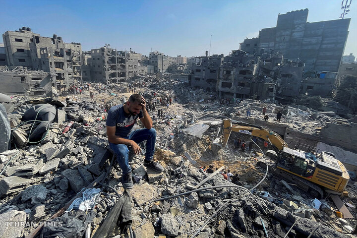 A man reacts as Palestinians search for casualties a day after Israeli strikes on houses in the Jabalia refugee camp in the northern Gaza Strip. [Mohammed Al-Masri/Reuters]
