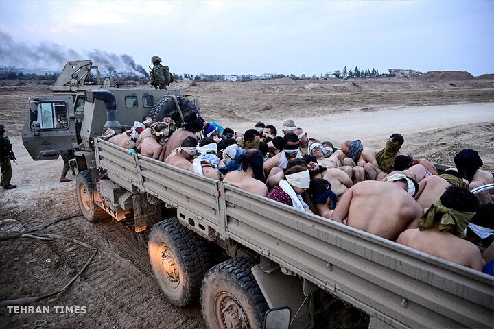 Israeli soldiers stand by a truck packed with shirtless Palestinian detainees. Israeli tactics against Palestinian civilians have been criticised, with rights groups accusing Israeli soldiers of committing war crimes. [Yossi Zeliger/Reuters]
