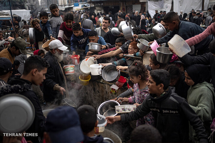 Palestinians line up for food in Rafah. International aid agencies say Gaza is suffering from shortages of food, medicine and other essential supplies as a result of the war. The UN says Gaza is on the brink of famine. [Fatima Shbair/AP Photo]
