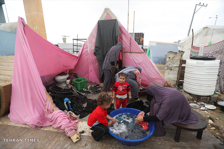 Displaced Palestinians, who fled their houses due to Israeli strikes, shelter in a tent camp in Rafah. [Ibraheem Abu Mustafa/Reuters]
