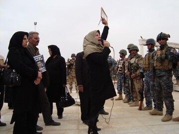 Soraya Abdollahi speaking into a mic outside MEK’s Camp Ashraf in Iraq, where she spent four years between 2009 and 2013, asking to see her son