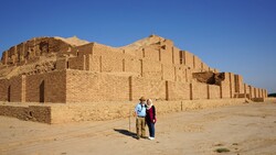 Foreign travelers pose for a photo in front of the UNESCO-registered Tchogha Zanbil, a ruined Elamiate-era ziggurat in southwest Iran.