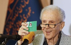 Cartoonist Hassan Tofiq shows his Tofiq certificate to journalists during a press conference in an undated photo. (IRNA/Mehdi Jafari)