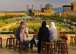 Travelers sit overlooking the UNESCO-registered Imam Square in Isfahan, central Iran.