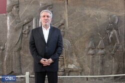 Minister of Cultural Heritage, Tourism and Handicrafts Ali-Asghar Mounesan stands in front of an Achaemenid-era (c. 550-330) bas-relief carving in an undated photo. 