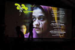 Presenter steps on the stage to read the award for best screenplay during the closing ceremony of the 24th Sofia International Film Festival in the Bulgarian capital of Sofia on July 6, 2020