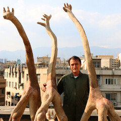 Afghan sculptor Alikhan Abdollahi poses with a number of his works in an undated photo. 