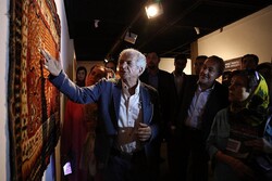 A file photo shows Iranian sculptor Parviz Tanavoli and art aficionados visiting an exhibition of his Persian flatweave rugs, kilims and carpets.
