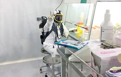 An Iranian researcher at a laboratory makes the V sign as the country has high hopes for developing a COVID-19 vaccine.