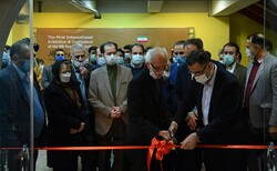 Veteran calligrapher Gholamhossein Amirkhani (L) and Iranian National Commission for UNESCO director Hojjatollah Ayyubi cut a ribbon to inaugurate the First Raqs-e Qalam International Exhibition