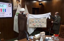 Islamic Ideology Dissemination Organization director Hojjatoleslam Mohammad Qomi (L) and an unidentified person unveil a poster for a collection of books on the Second Phase of the Revolution statemen