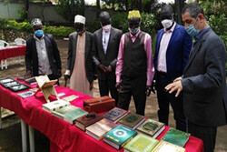 An organizer (R) talks to visitors at a Quran exhibition underway at the culture center of the Embassy of Iran in Kampala, Uganda. 