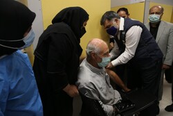 WHO representative to Iran Jaffar Hussain injects a vaccine into a client in a visit to a COVID-19 vaccination center in Tehran on August 25.