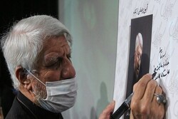 Eulogist Sadeq Ahangaran autographs a poster for his memoirs “Book of Ahangaran” in a meeting organized at Tehran’s Arasbaran Cultural Center on September 20, 2021 to introduce the book.      