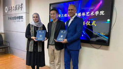 Director Narges Abyar (L) and cultural activist Hossein Khalifi (R) pose with an unidentified person after being decorated with the title of honorary professor of the Xi’an Jiaotong University. 