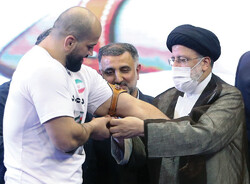 President Raisi gives Sadeghzadeh Pahlevani’s armband