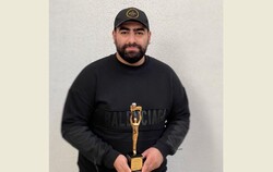 Mohammad Badrlu holds his award after being selected as Iran’s Still Photographer of the Year at the Iranian House Cinema in Tehran on December 13, 2021. 