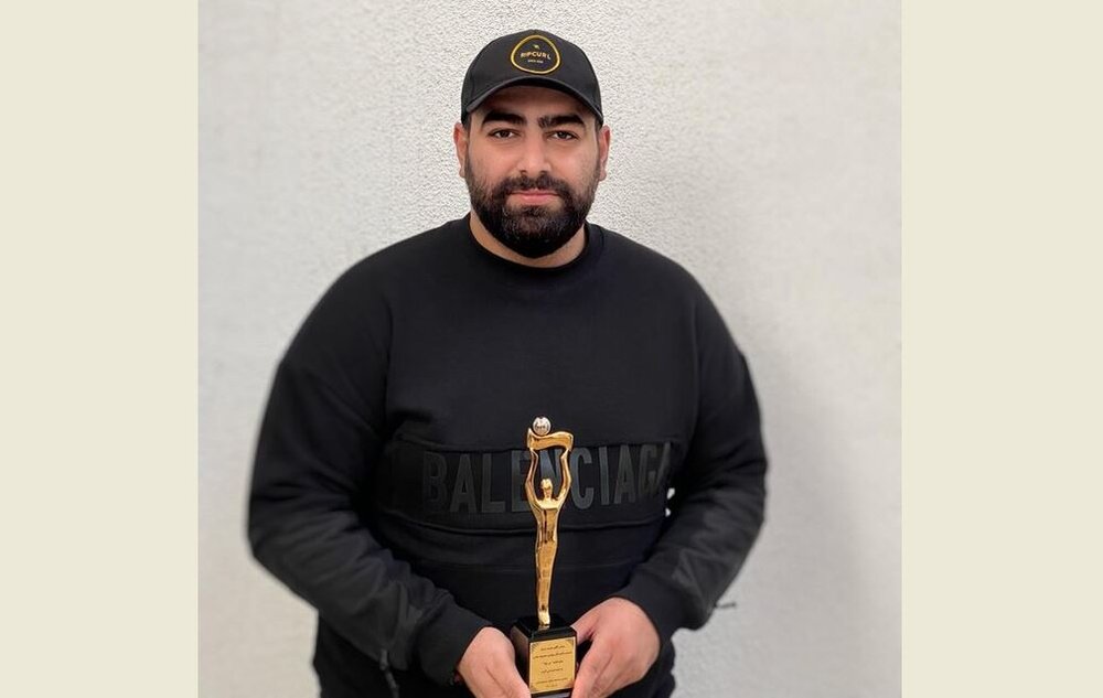 Mohammad Badrlu holds his award after being selected as Iran’s Still Photographer of the Year at the Iranian House Cinema in Tehran on December 13, 2021.