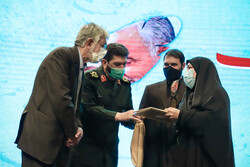 A poet (R) receives a prize from IRGC’s Muhammad Rasulallah Division chief Second Brigadier General Hassan Hassanzadeh (2nd L) at a poetry night for General Qassem Soleimani at the Art Bureau in Tehra