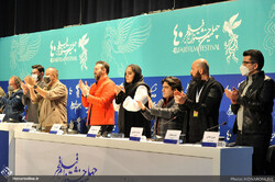 Crew members applaud Iranian war veterans in a press conference after the premiere of the war drama “2888” at Tehran’s Milad Tower on February 8, 2022. (Honaronline/Raha Ahmadi)
