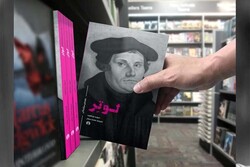 A file photo shows a seller putting a copy of the Persian edition of David M. Whitford’s book “Luther: A Guide for the Perplexed” on a shelf.