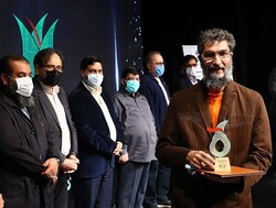 Mehrdad Rayani-Makhsus accepts the best director prize for “Concerns of the Hedge” during the Sarv Theater Awards at the Mehr Hall of the Art Bureau on February 28, 2022. (Theater.ir)