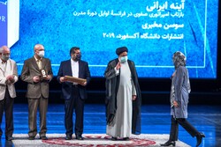 Susan Mokhberi (R) accepts an award from President Ebrahim Raisi for her book “The Persian Mirror” at the 39th Iran’s Book of the Year Awards at Tehran’s Vahdat Hall on March 15, 2022. (ISNA/Majid Kha