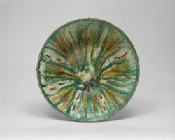 A 10th-century bowl with green, yellow, and brown splashed decoration; excavated in Iran, Nishapur