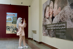 A visitor photographs a work on view in the exhibition “Toward Hope” at the Iranian Academy of Arts in Tehran on May 10, 2022. (IRNA/Meisam Alaqemandan)