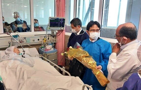 Japanese Ambassador Kazutoshi Aikawa (L) and his colleague accompanied by a medical team member visit Koniko Yamamura at Tehran’s Khatam al-Anbia Hospital on June 16, 2022.