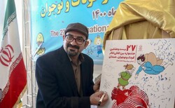 Amir Mashhadi-Abbas, the president of the 27th International Theater Festival for Children and Young Adults, signs a poster for the event after a press conference on June 14, 2022.