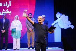 Director Mohammad Jahanpa accepts the award for his play “A Soup for the Reconciliation Party” at the 27th of Iran’s International Theater Festival for Children and Young Adults in Hamedan on June 27,