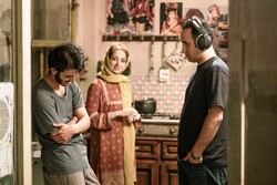 Navid Mahmudi (R) directs Ali Shadman (L) and Neda Jebraili in a scene from “Drowning in Holy Water”.