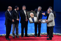 Composer Hamid Shahangian (R) accepts an award for his lifetime achievements at the Fajr National and International Anthem Festival at Tehran’s Vahdat Hall on July 13, 2022. (IRNA/Asghar Khamseh)