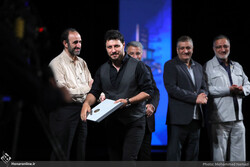 Javad Ezzati (2nd L) accepts the best actor award for his role in “The Loser Man” during the 8th Shahr International Film Festival at Tehran’s Vahdat Hall on July 22, 2022. (Honaronline/Mohammad Namaz