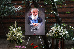 A portrait of Amir-Hushang Ebtehaj is placed in memory of the Iranian poet under the renowned Judas tree at his home in Tehran on August 13, 2022. (ISNA/Sara Sabzi)