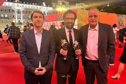 Director Behruz Shoeibi (C) poses with jury member Rasul Sadr-Ameli (R) and an unidentified person in Moscow on September 2, 2022, after his film “No Prior Appointment” won the Golden Saint George for
