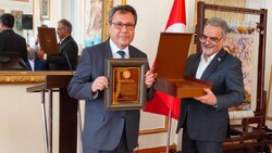 Turkish scholar Ali Temizel (L) holds the Shahriar Medal after receiving the decoration from Iranian Ambassador Mohammad Farazmand (R) at the Embassy of Iran in Ankara.