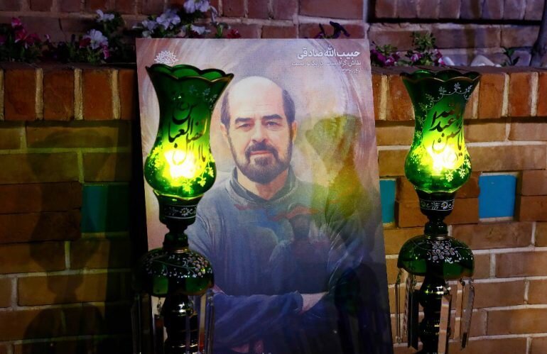 A picture of Habibollah Sadeqi is seen during a memorial for the artist at the Art Bureau in Tehran on August 1, 2022. (AB/Mohsen Seyyedi)