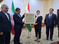 Iran’s Minister of Culture and Islamic Guidance, Mohammad-Mehdi Esmaeili (2nd L), poses with a present he received from his Tajik counterpart, Zulfiya Davlatzoda (2nd R), in Dushanbe on October 31, 20