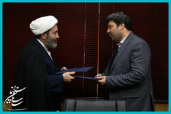 ICRO director Mohammad-Mehdi Imanipur (L) and COI director Mohammad Khazaei exchange documents after signing a memorandum of understanding in Tehran on November 26, 2022. (COI)