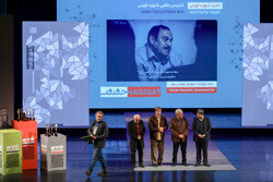 Iranian director Behruz Nuranipur (L) accepts the award for best full-length documentary for his film “Se-Nohezarom” during the 16th Cinéma Vérité festival at Vahdat Hall, Tehran, on December 16, 2022