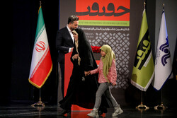Director Mahdieh Sadat Mehvar and her daughter walks onto the stage to receive the award for best documentary for her film “Aziz” during the 16th Cinéma Vérité festival at Tehran’s Vahdat Hall on Dece