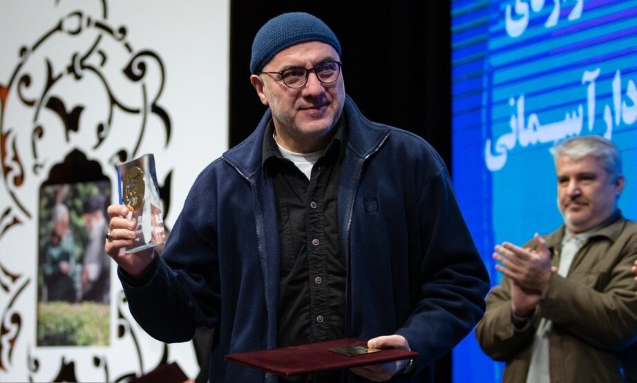 Actor Farhad Qaemian accepts a lifetime achievement award at the 4th Divine Commander Theater Festival at Tehran’s Arasbaran Cultural Center on January 10, 2023. (Fars/Hadi Hirbodvash)