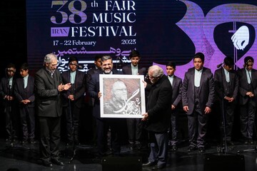 Songwriter Hamid Shahangian (R) receives a portrait of himself from Culture Minister Mohammad-Mehdi Esmaeili during the 38th Fajr Music Festival at Tehran’s Arasbaran Cultural Center on February 19, 2