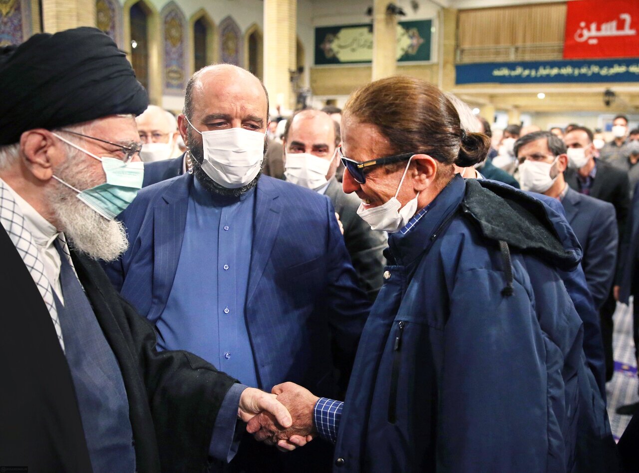 Leader of the Islamic Revolution Ayatollah Seyyed Ali Khamenei shakes hands with poet Qader Tahmasbi in his annual meeting with Iranian literati on April 5, 2023. (Khamenei.ir)