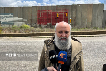 Iranian graphic designer Masud Nejabati attends an interview at the foot of the graffiti “A Victory Near at Hand” in southern Lebanon on April 13, 2023. (Art Bureau) 